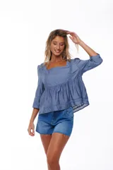 Blusa celeste con escote cuadrado, mangas 3/4 abullonadas y detalle de puntilla en escote y mangas.
