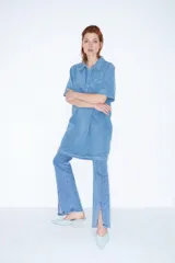 Pantalón de jean de tiro alto, corte ajustado y botamanga acampanada con tajos laterales.