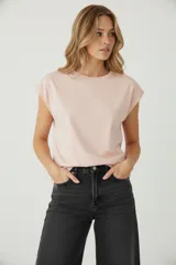 Remera de algodón color rosa pálido, con cuello redondo a la base y mangas cortas dobladas. Corte holgado.