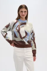 Sweater de punto con estampado abstracto en tonos marrón, celeste, blanco y verde. Tiene cuello redondo y corte holgado.