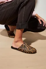 Slippers con estampado animal print, forro y plantilla de cuero negro.