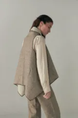 Chaleco marrón con diseño a cuadros, solapas anchas y bolsillos laterales.