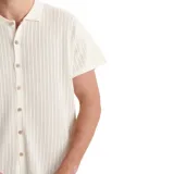 Camisa de punto de manga corta marca Critical Slide, modelo Intro, en color blanco. Presenta cuello polo, cierre frontal de botones y un diseño con textura de líneas verticales caladas.