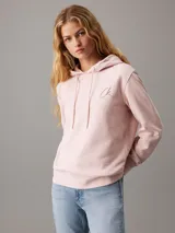 Buzo rosa claro de felpa de algodón con capucha y cordones ajustables. Tiene puños y bajo acanalados, y logo de Calvin Klein bordado en el pecho.
