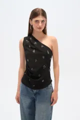 Top negro asimétrico con un solo bretel ancho, bordado con cuentas y cierre lateral.