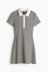 Vestido corto a rayas horizontales blancas y negras, con cuello blanco tipo polo, tapeta de botones y falda acampanada.