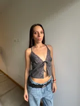 Top gris con breteles finos, escote en V con terminación de encaje y lazo ajustable en el centro.