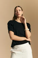 Remera negra de manga corta con mangas abullonadas y cuello redondo.