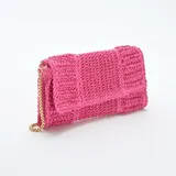 Bolso de mano tipo clutch color fucsia, tejido en rafia, con solapa y cadena dorada para usar como bandolera.