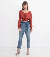 Blusa color ladrillo con escote redondo con ajuste, mangas largas con aberturas en los hombros y elástico en la cintura.