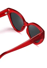 Gafas de sol con forma de ojo de gato, montura de acetato biodegradable color verde y lentes de PMMA reciclado color negro.