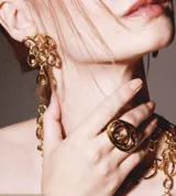 Par de aros colgantes dorados con forma orgánica y strass incrustados.