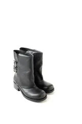 Botas de cuero negro con caña baja, botamanga y hebillas laterales.