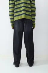 Pantalón de jean negro de corte amplio estilo skater, con tiro medio, cierre de botón y cremallera, y diseño clásico de cinco bolsillos.