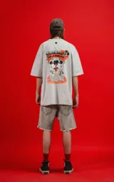 Remera color gris claro de corte oversize, con cuello redondo y mangas cortas. Estampado en la espalda con Mickey y Minnie Mouse sentados sobre una roca, con llamas y el texto 'Hello Darling'.