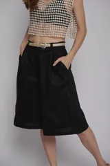 Bermuda blanca de lino, corte sastre, tiro alto, largo a la rodilla y bolsillos laterales.