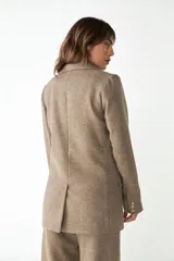 Blazer marrón de lana con solapas de muesca, cierre con dos botones dorados, bolsillos con solapa y forro interior a tono.