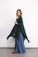 Ruana tejida en lana merino color amarillo pastel, con terminación de flecos.