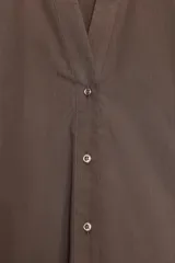 Camisa marrón de popelina con cuello solapa, escote en pico, cierre frontal con botones y mangas anchas con puños.