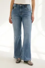 Pantalón de jean azul de corte acampanado, con bolsillos delanteros y traseros, y detalle de cuero sintético en la cintura.