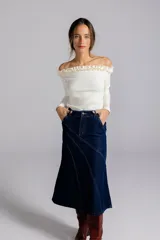 Falda midi negra de jean con corte evasé y costuras diagonales.