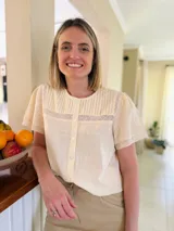 Camisa color amarillo manteca de lino, con cuello a la base, tablitas en el frente y puntilla.