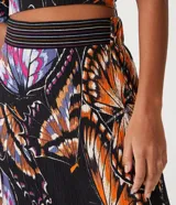 Pollera midi de viscosa con estampado de mariposas, cintura elastizada con pespuntes de colores y ruedo fruncido.