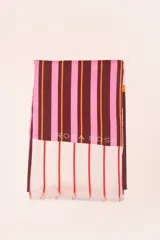 Pareo rectangular de viscosa con estampado de flores rojas sobre fondo borgoña y borde inferior con rayas verticales rojas, amarillas y blancas.