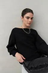 Sweater negro tramado de silueta relajada, con combinación de texturas en el tejido y mangas abullonadas con puños elastizados.