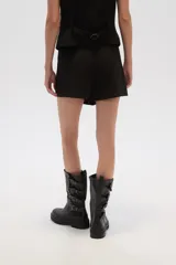 Minifalda negra con corte asimétrico y detalle de tabla en el frente.