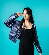 Bomber azul marino de cuero con mangas ranglán, bolsillos laterales, elástico en la cintura y cierre metálico delantero.