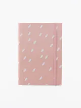 Libreta A5 con tapa rosa y estampado de puntos blancos. Tiene un elástico rosa para sujetar la tapa.