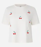 Remera color crema de algodón con bordados de cerezas rojas y hojas verdes.