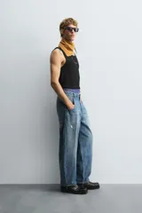 Pantalón de jean azul de corte amplio, con roturas y lavado gastado.