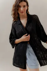 Saco calado negro tejido a máquina, con cuello tipo camisa y mangas 3/4.