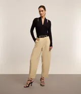 Blusa negra de mangas largas confeccionada en viscosa, con cuello alto, escote V y aberturas en los hombros.