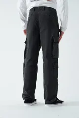Pantalón cargo negro de canvas, tejido de algodón grueso, con tiro medio, pasa cintos y cuatro bolsillos cargo.