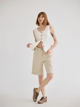 Short color beige de lino, de tiro medio, con bolsillos laterales y ruedo con dobladillo.