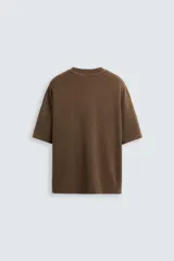 Camiseta azul marino de corte holgado, confeccionada en algodón con cuello redondo y mangas cortas. Presenta un efecto de lavado que le da una apariencia única.