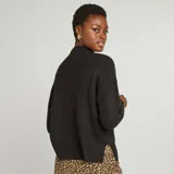 Sweater negro de punto suave con cuello alto y corte holgado.