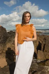 Musculosa tejida color marrón con diseño calado y flecos en los hombros.