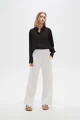 Pantalón blanco de viscosa, de corte recto y tiro alto, con bolsillos laterales y cintura elástica.