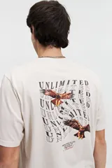 Remera color crema de manga corta con estampado de águilas y texto distorsionado en la espalda. Corte regular.