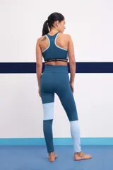 Calza deportiva larga de tiro alto, color azul con paneles laterales en celeste y blanco.