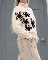 Sweater de lana merino, color blanco con estampado gráfico en negro y cuello alto.