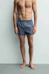 Calzoncillo tipo bóxer confeccionado en popelín de algodón con estampado de cuadros azules y blancos.