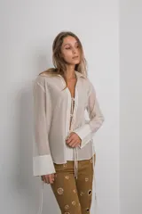 Camisa negra de organza con mangas largas y tiras de ajuste en el frente y puños.