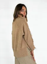 Sweater beige de tejido de punto con detalle de flecos en hombros y mangas.