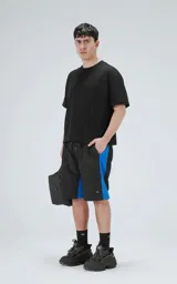 Short negro con cintura elastizada, cordón de ajuste y bolsillos laterales. Presenta una franja azul en los laterales.