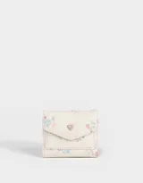 Billetera pequeña de cuerina color crema con estampado floral en tonos rosa y celeste. Tiene solapa con broche a presión en forma de corazón.